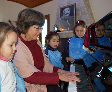 Susan playing the piano for school guests
